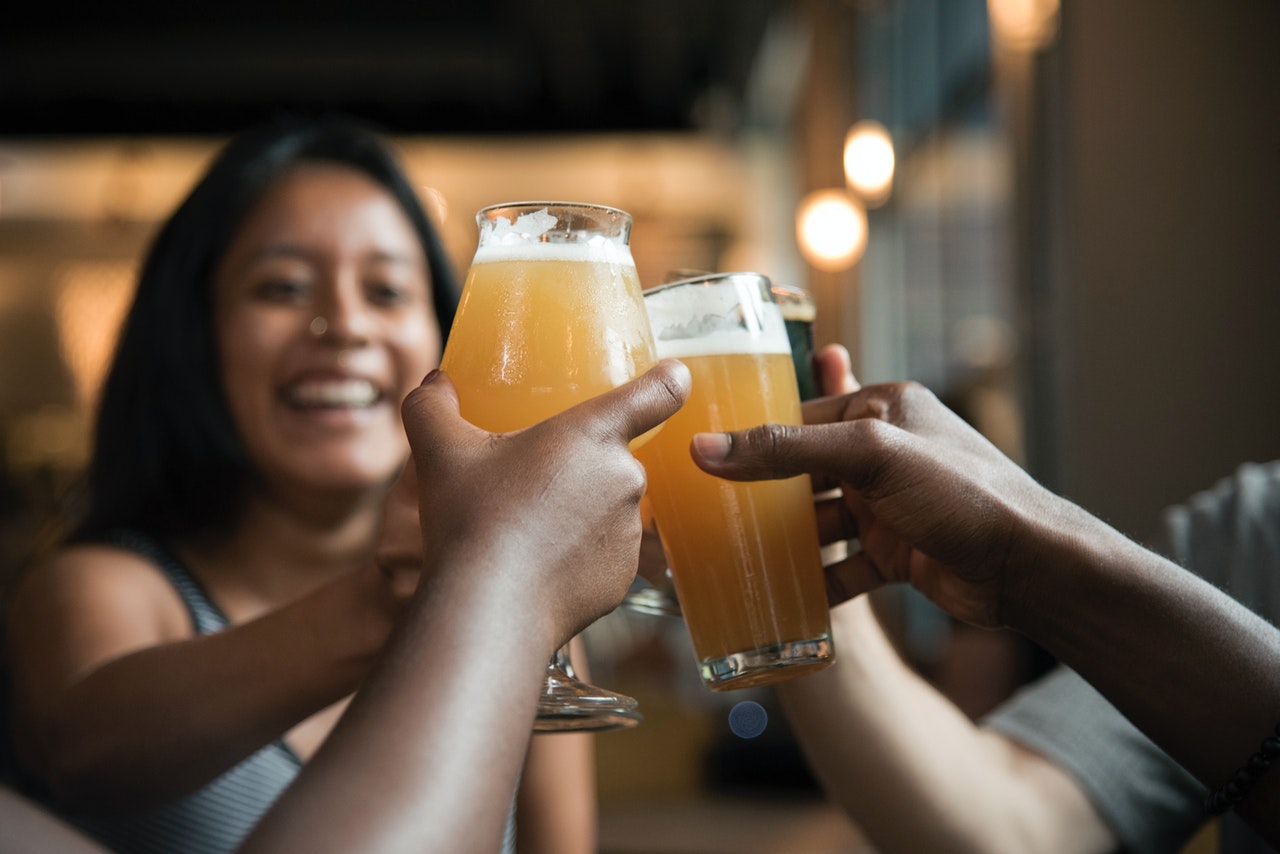 Personer drikker øl sammen på bar